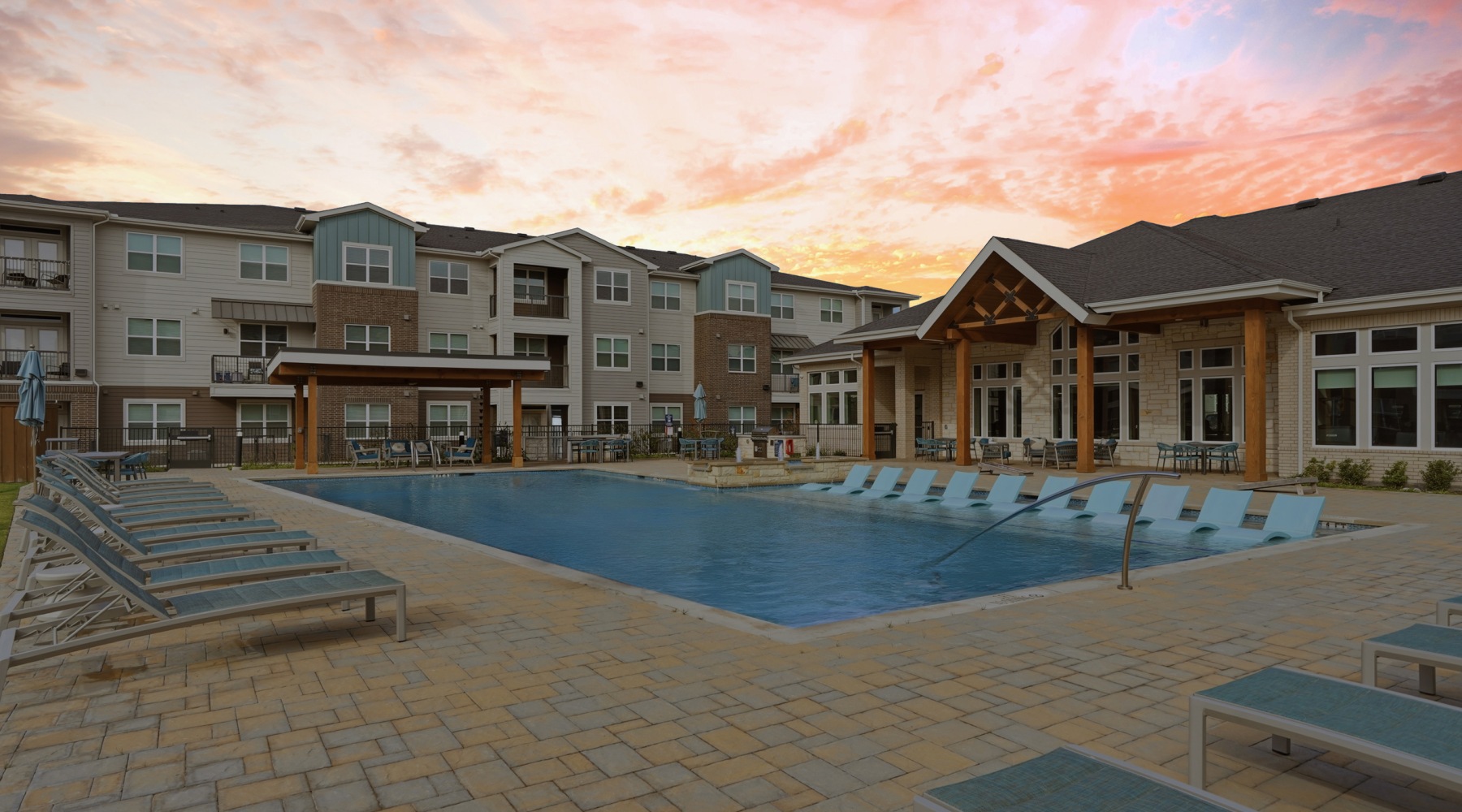 pool with lounge chairs and sunset